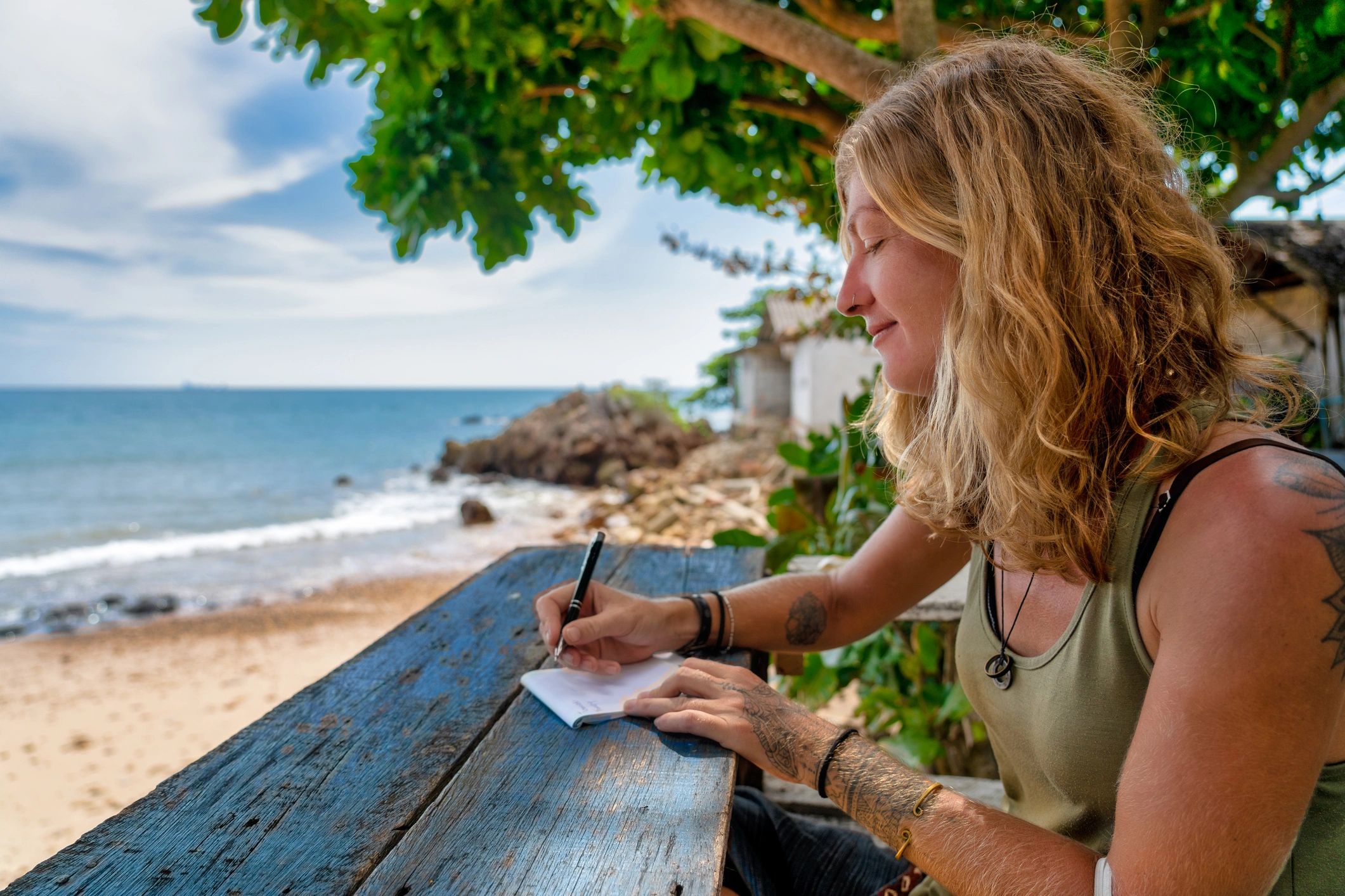 Travel writer taking notes beside the beach